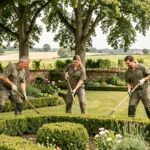 Équipe de paysagistes professionnels entretenant un jardin verdoyant en Gironde avec haies taillées et pelouse soignée